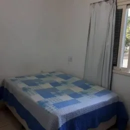 Foto de um quarto com cama coberta por lençóis azuis e brancos.