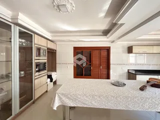 Ambiente interno de uma cozinha com armários de madeira e portas de madeira.
