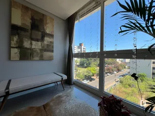 Sala de estar com grandes janelas que oferecem uma vista externa.