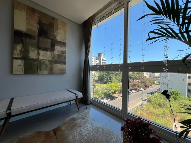 Sala de estar com grandes janelas que oferecem uma vista externa.