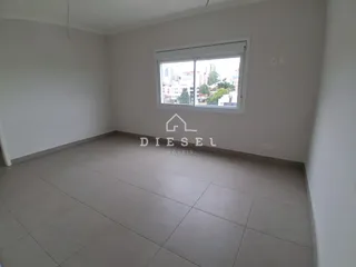 Ambiente interno de uma sala com piso de cerâmica e janela.