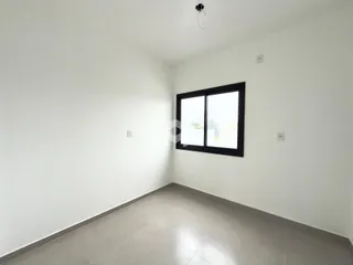 Ambiente interno de um cômodo com paredes brancas e piso cinza claro.