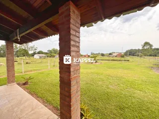 Uma vista externa mostrando um pilar de tijolos e um campo gramado.