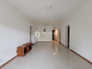 Interior de um corredor com piso claro e paredes brancas.