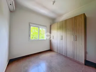 Quarto com janela e armário de madeira em ambiente claro.
