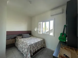 Quarto com cama e janela em ambiente claro.