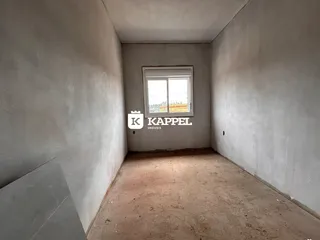 Hall de entrada com paredes lisas e piso de concreto.