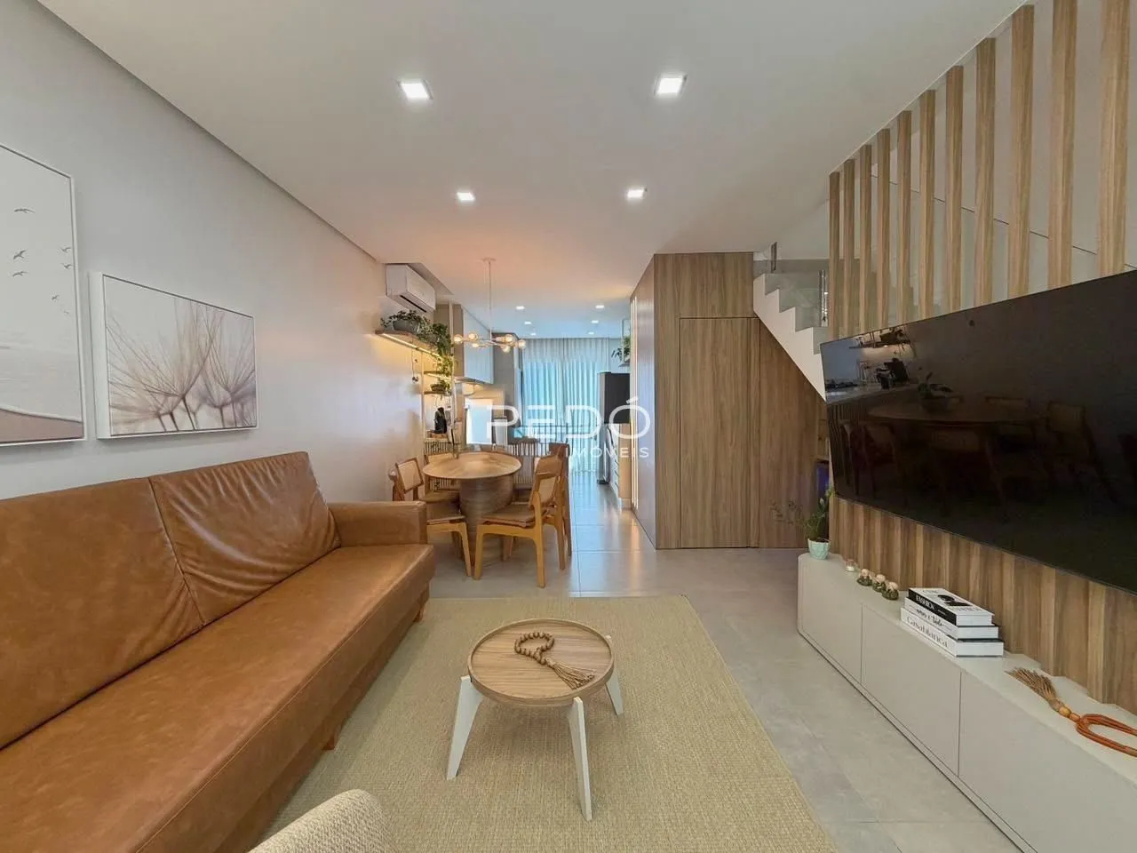 Sala de estar com sofá marrom e decoração moderna em um imóvel no Brasil.