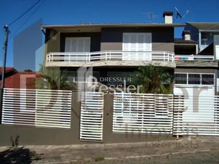 Fachada de uma residência em Lajeado, Brasil, com cerca e portão branco.