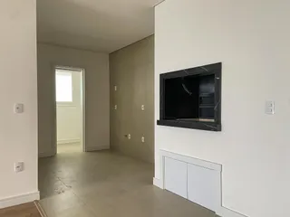 Hall de entrada com paredes claras e piso de concreto.