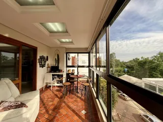 Sala com piso de tijolo e vista para a paisagem externa.
