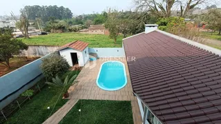 Vista do quintal com piscina e telhado de telhas.