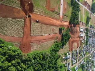 Vista aérea da área com terra e vegetação ao redor de uma residência.