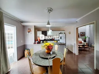 Foto de um ambiente de jantar com mesa redonda e cadeiras em uma cozinha moderna.