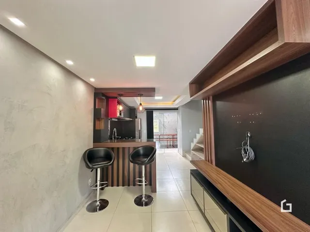 Vista de um ambiente interno moderno com cozinha e área de passagem.