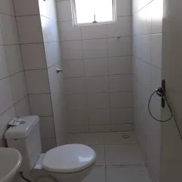 Foto de um banheiro com revestimento de azulejos brancos.