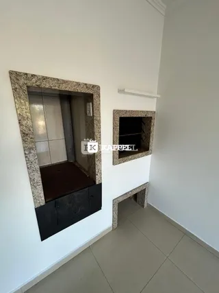 Uma parede branca com nichos decorativos em pedra é visível no interior da propriedade.