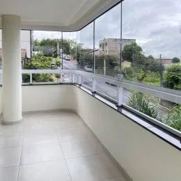 Vista de um ambiente interno com grandes janelas e para uma área externa.