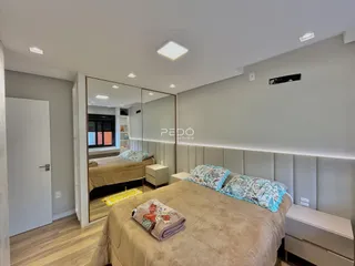Quarto com cama grande e espelho em um imóvel no Brasil.