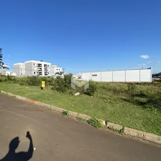Vista externa de uma propriedade com gramado e estrada no primeiro plano.