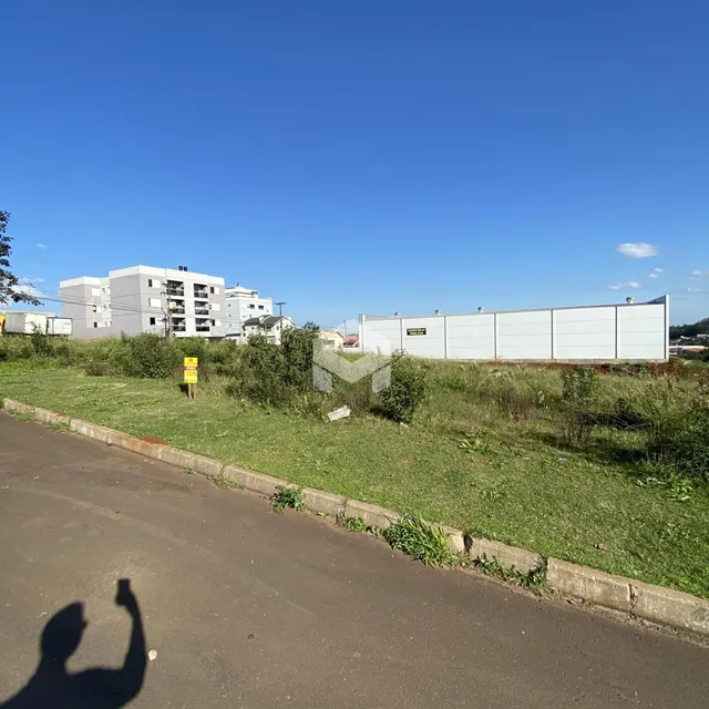 Vista externa de uma propriedade com gramado e estrada no primeiro plano.