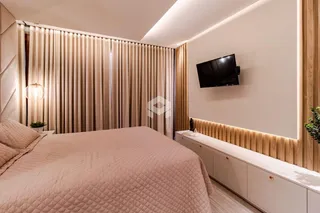 Quarto com cama e cortinas em um ambiente moderno.