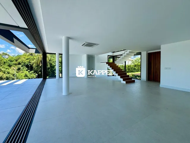 Sala de estar ampla com vista para a área externa verde.