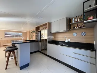 Vista da cozinha moderna com armários e bancadas escuras.