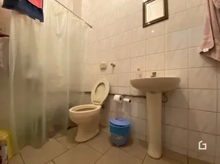 Foto de um banheiro com revestimento de azulejos brancos.