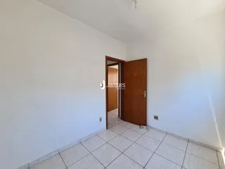 Hall de entrada com piso cerâmico e portas de madeira em uma residência.