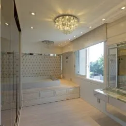 Quarto com teto decorado por lustre de cristal.