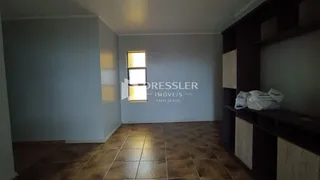 Ambiente interno de uma sala com piso de cerâmica e janela.
