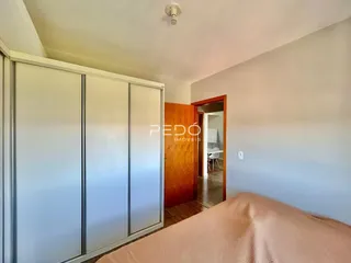 Quarto com armários embutidos e cama em primeiro plano.