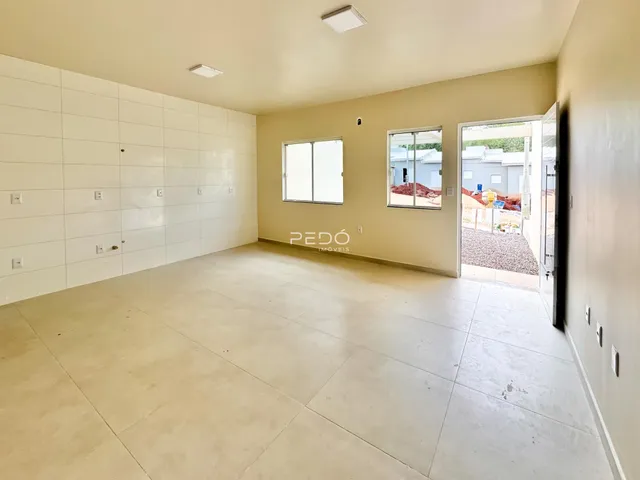 Foto de um ambiente interno com paredes brancas e piso claro.