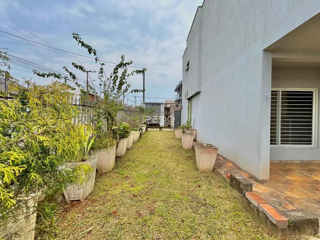 Vista da fachada de uma residência com jardim lateral.
