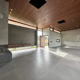 Interior amplo com teto de madeira e piso claro em um espaço comum.