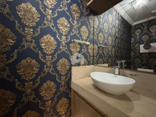 Foto de um banheiro com revestimento de parede em padrão dourado.