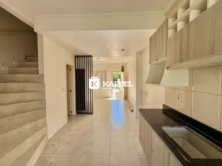 Hall de passagem com piso claro e armários de cozinha modernos.