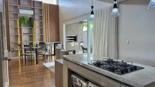 Ambiente interno com piso de madeira e área de jantar em um imóvel.