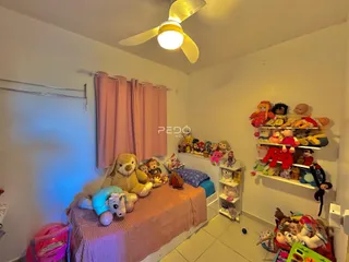 Quarto decorado com brinquedos e cortinas em uma residência.