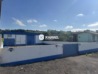 Vista externa de um prédio industrial com muro azul e branco em Lajeado.