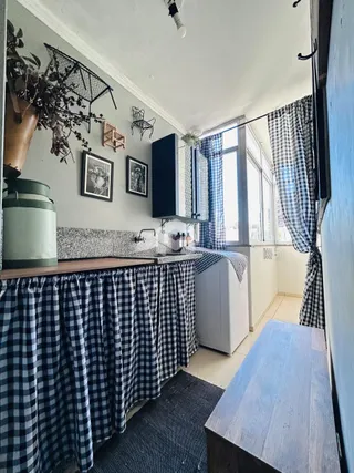 Interior de uma sala com revestimento de azulejo e cortinas.