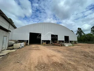 Fachada de um galpão industrial com grandes portas de metal em Lajeado, Brasil.