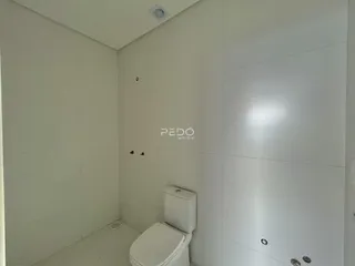 Um banheiro com paredes brancas e piso claro.