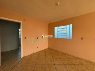 Hall da casa com paredes alaranjadas e piso de cerâmica.