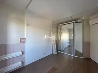 Interior de um ambiente com piso de madeira e paredes claras.