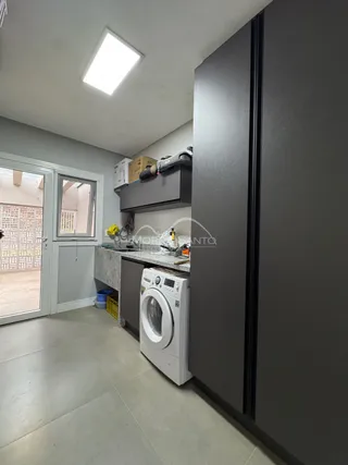 Foto de uma área de serviço com máquina de lavar roupa.