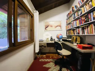 Ambiente interno de um escritório com janela de madeira.