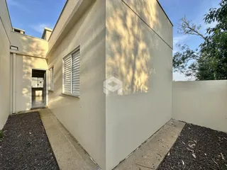 Fachada lateral de uma residência em Lajeado, Brasil, com uma janela e um caminho de concreto.