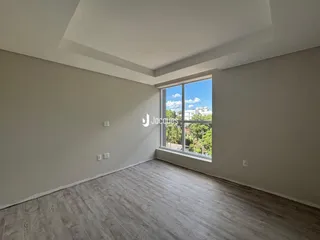 A sala de estar apresenta um piso claro e paredes brancas.